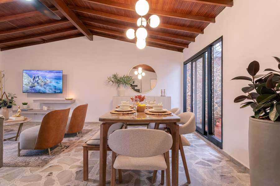 Dining area with mosaic-top table, 58" smart TV and sliding doors to the terrace