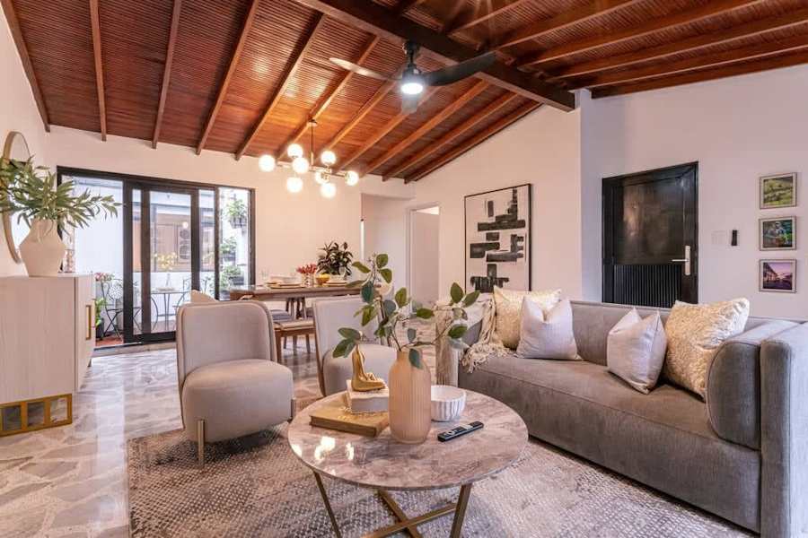 Living room with sofa and armchairs under a wood-beam ceiling