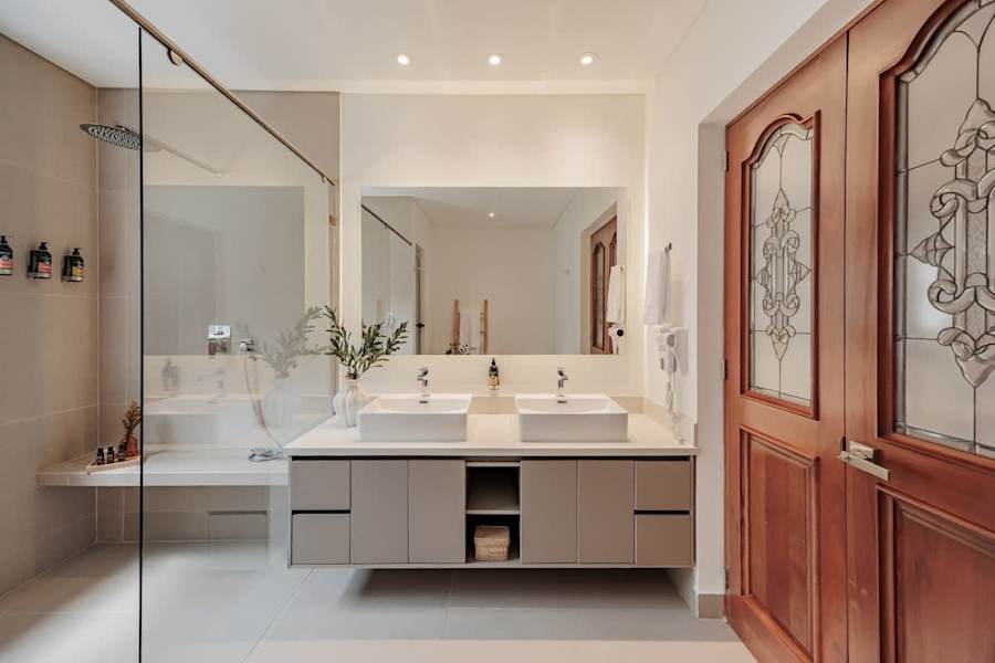 Primary Suite - Ensuite Bathroom : Elegant master bathroom with double sinks, hair dryer, and premium L’Occitane amenities including shampoo, shower gel, and conditioner—designed for comfort and luxury.