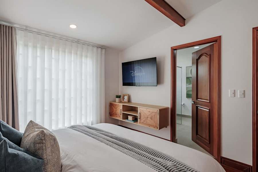 Private Suite # 2 – Elegant queen bedroom with Smart TV, A/C, and direct access to a private en-suite bathroom.