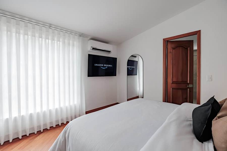 Private Suite # 3 – Queen bedroom with Smart TV, A/C, full-length mirror, and direct access to a private en-suite bathroom.