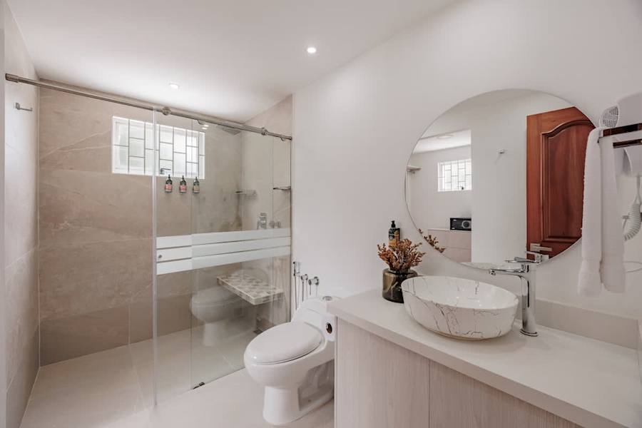 Private Ensuite #3: Spa Comfort. Indulge in a rejuvenating rain shower featuring elegant marble-style walls and an integrated seating bench. Includes world-class L’Occitane toiletries to elevate your daily refresh.