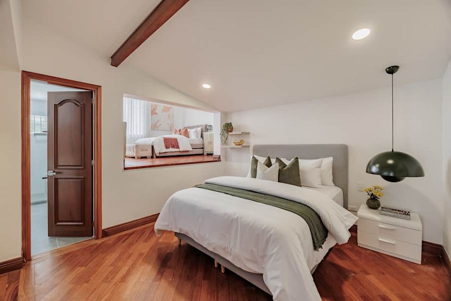 Family Suite # 4 – Main queen bed with Smart TV, digital safe, independent A/C, and private en-suite bathroom. The suite also includes a full bed on the mezzanine and a pull-out trundle bed.